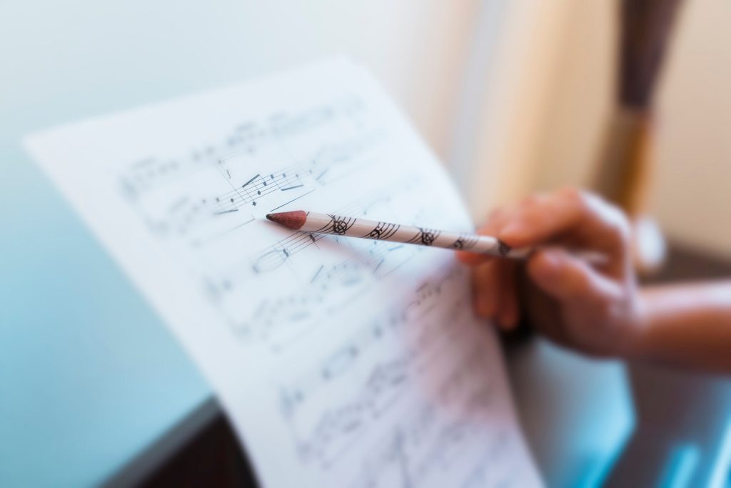 Teacher pointing to how to read music for online singing lessons in Halifax