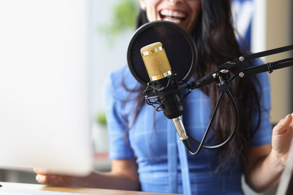 Singing Teacher in Halifax wearing blue dress and singing into microphone