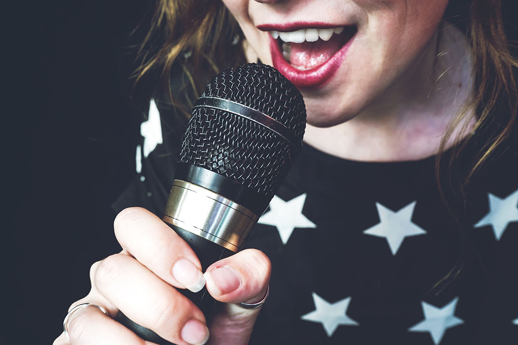 Young woman singing a song getting online singing lessons in barnsley